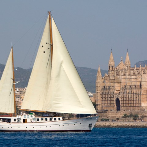 a large white boat sitting next to a body of water