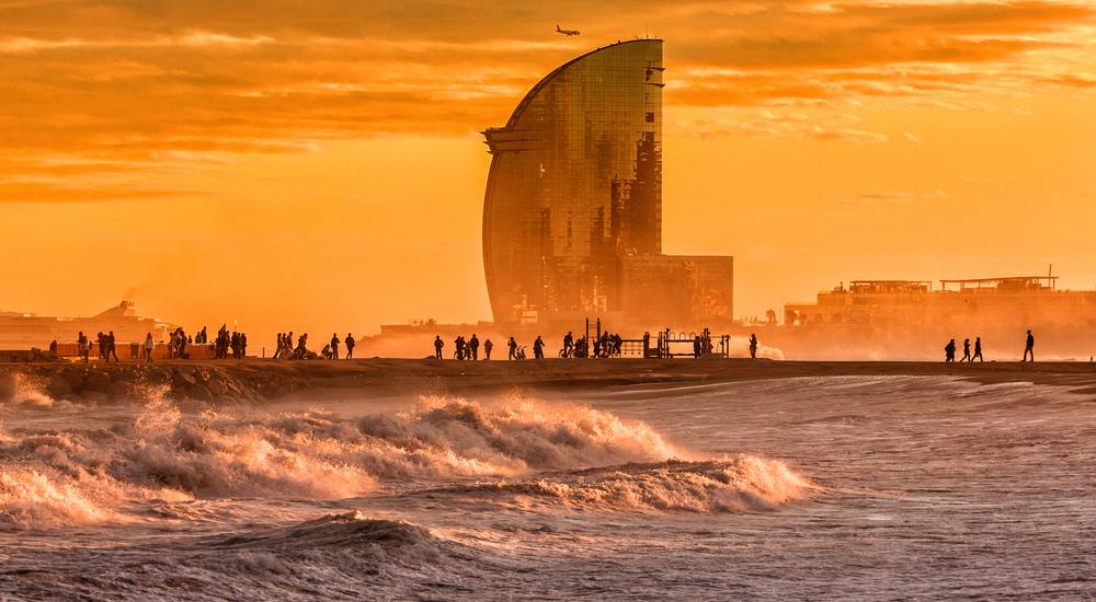 sunset in barcelona a sunset over a body of water