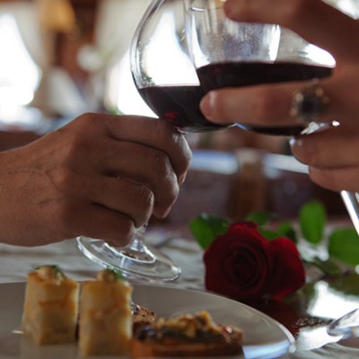 a woman sitting at a table with wine glasses