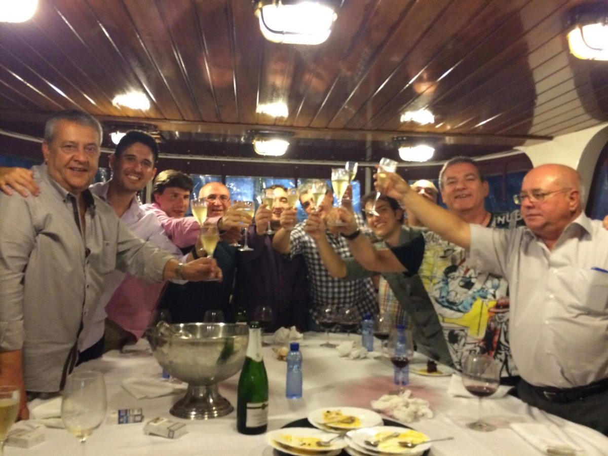 a group of people standing around a table with wine glasses