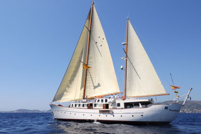 a large white boat sitting next to a body of water