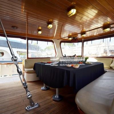 a room filled with furniture and a large window in a back saloon with table ready to receive the guests