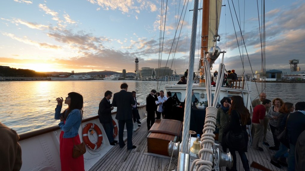 un grup de persones disfrutant d'un aperitiu a la posta de sol abans de sopar al vaixell