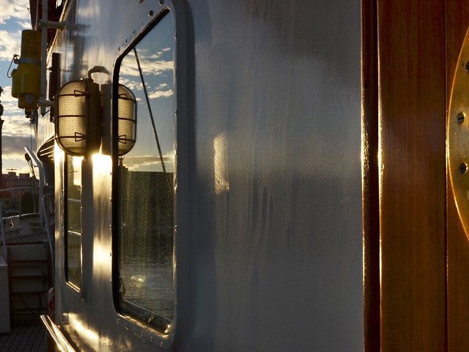 a clock sitting in front of a mirror. Old elements of the historic boat