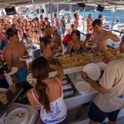 a group of people standing in front of a crowd, waiting for the bbq