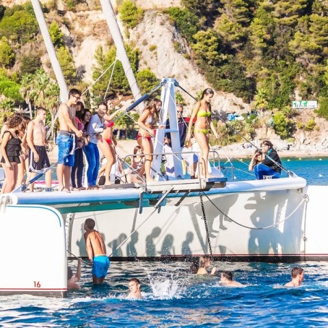 a group of people riding on the back of a boat and jumping from the trampolin