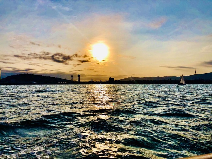 Navegar con velero en otoño a sunset over a body of water