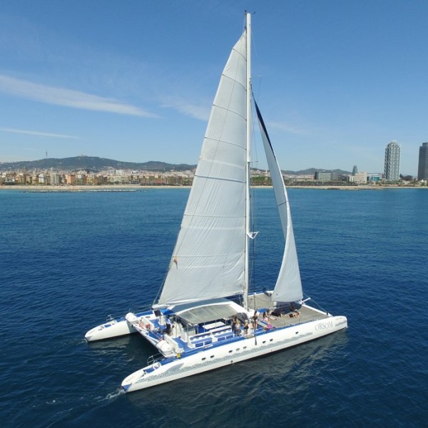 Catamaran Orsom con la ciudad de Barcelona al fondo