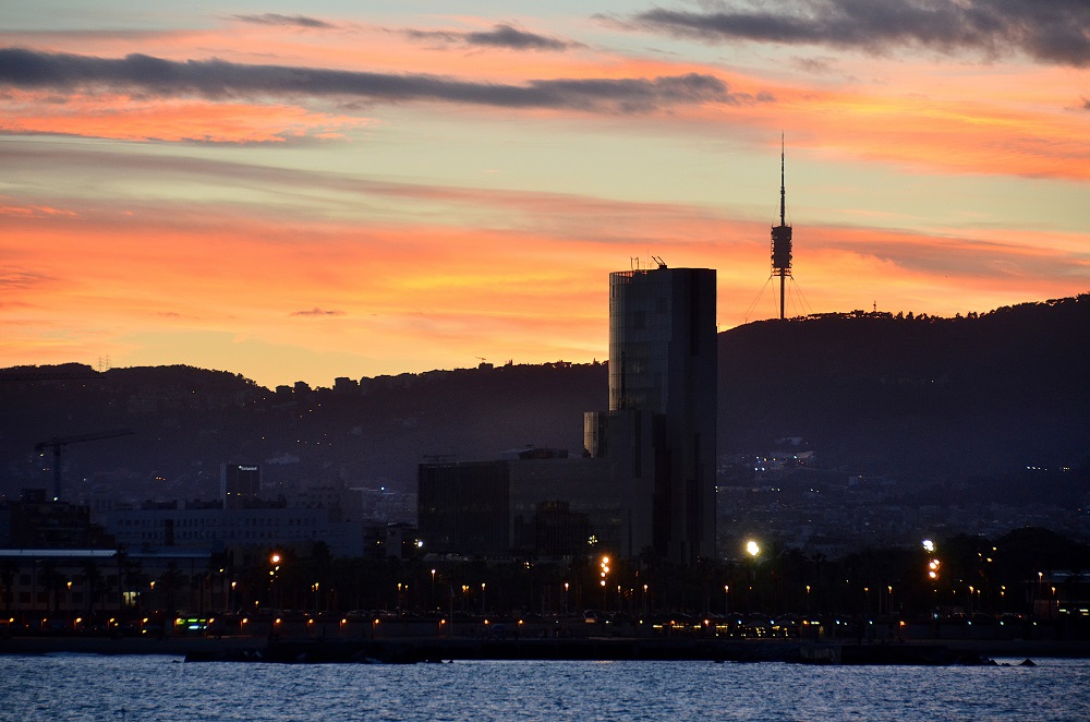 a sunset over a body of water with a city in the background