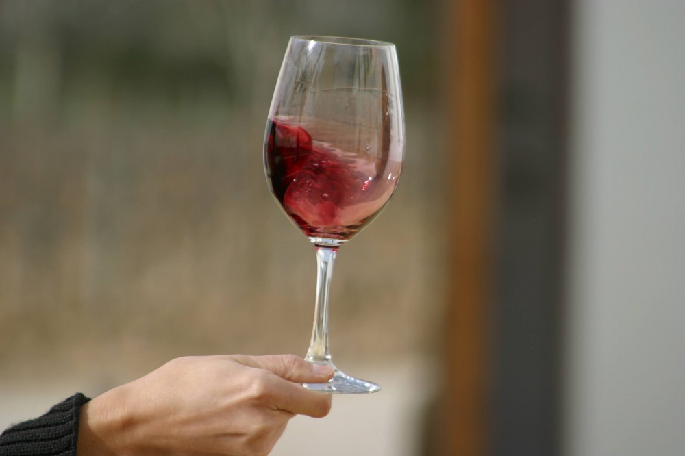 a hand holding a glass of wine