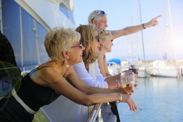 Senior man showing something to their friends on a yacht a person holding a glass of water. Yacht, Enjoying life, Summer Vacation, Wealthy friends, Marina, Summer sun
