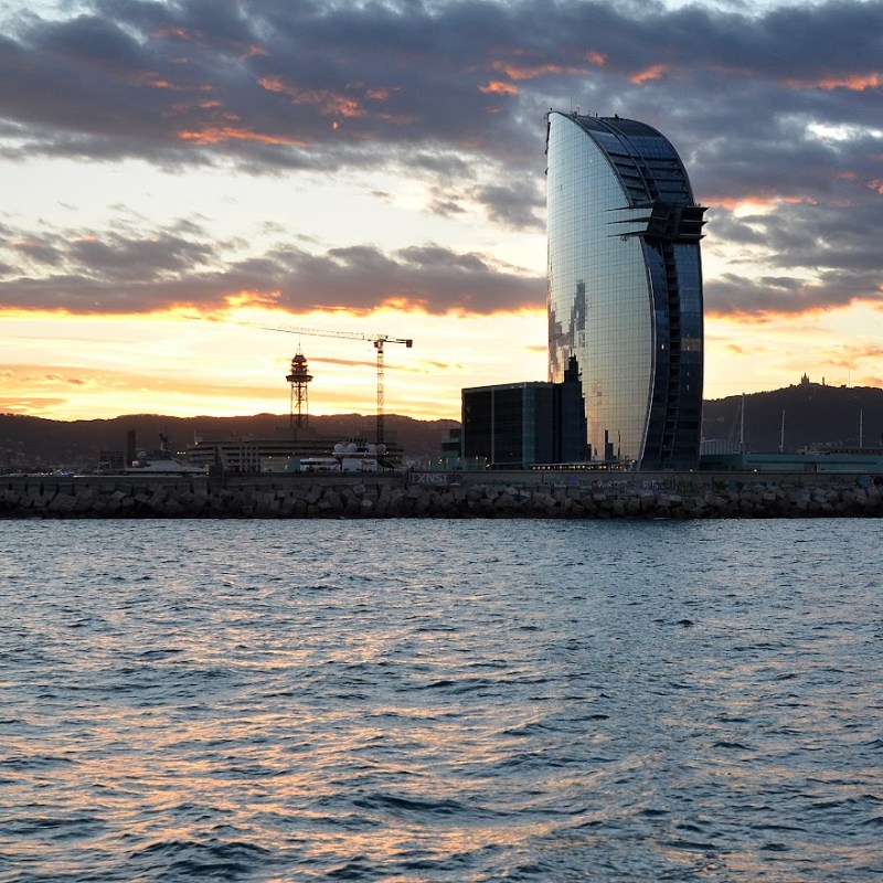 a sunset over a body of water with a city in the background