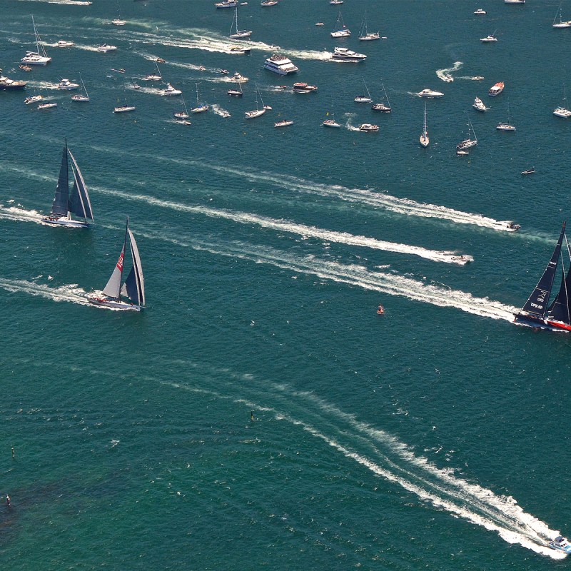 a group of people flying kites in a body of water