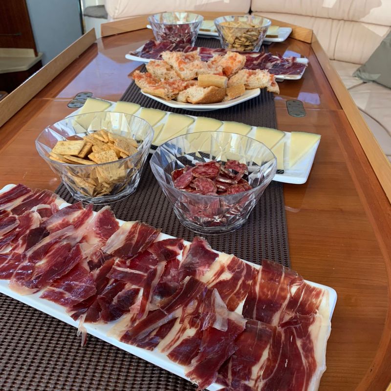 Assortment of meats, cheeses, and bread on a wooden table.