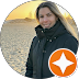 Person in black jacket on a beach during sunset with orange star icon.