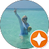 Person in blue water holding a drink with an orange star badge overlay.